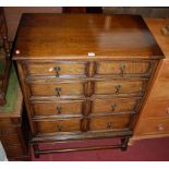 An early 20th century oak chest of four long graduated drawers, having turned brass tear drop