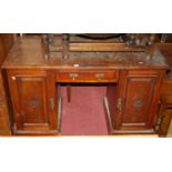 An Edwardian line carved walnut and pitch pine topped kneehole desk, having single central drawer