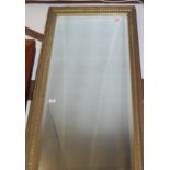 A gilt framed and bevelled rectangular wall mirror, late 20th century, 130x57cm