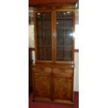 An early 19th century mahogany and satinwood strung bookcase cupboard, having twin glazed upper