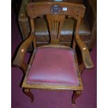 An early 20th century oak splatback elbow chair, the bar back carved with St Edmundsbury Borough