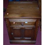 A contemporary Ercol dark elm low single door side cupboard, having single upper drawer, w.52cm