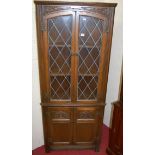A contemporary Old Charm moulded oak and lead glazed free standing corner cupboard, width 69cm