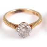 A yellow and white metal diamond single stone ring, comprising a round brilliant cut diamond in an