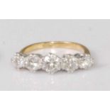 An 18ct gold and platinum diamond five stone ring, the graduated claw set brilliants in a line