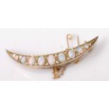 A late 19th century yellow metal, opal and diamond crescent brooch, featuring nine graduated oval