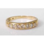 An 18ct gold diamond half hoop ring, the seven claw set brilliants in a line setting, total