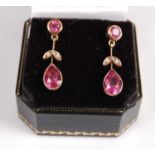 A pair of 9ct pink sapphire flower shaped drop earrings, each featuring a pear cut pink sapphire