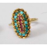 An 18ct gold, ruby and turquoise set dress ring, the large oval setting centre set with a row of