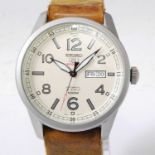 A gent's Seiko 5 Sports steel cased automatic wristwatch, having a signed cream dial, with day-