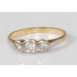 An 18ct gold and platinum diamond three stone ring, the round cut diamonds being illusion set, the