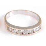 A yellow metal diamond seven stone half hoop eternity ring, featuring seven round brilliant cut