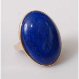 A yellow metal dress ring, featuring a 28 x 24mm oval lapis lazuli cabochon in a bezel setting,