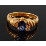 An 18ct yellow gold, sapphire and diamond dress ring, comprising an oval faceted sapphire with a