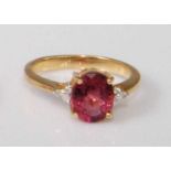 A contemporary 18ct gold, pink topaz and diamond point dress ring, the four claw set oval cut