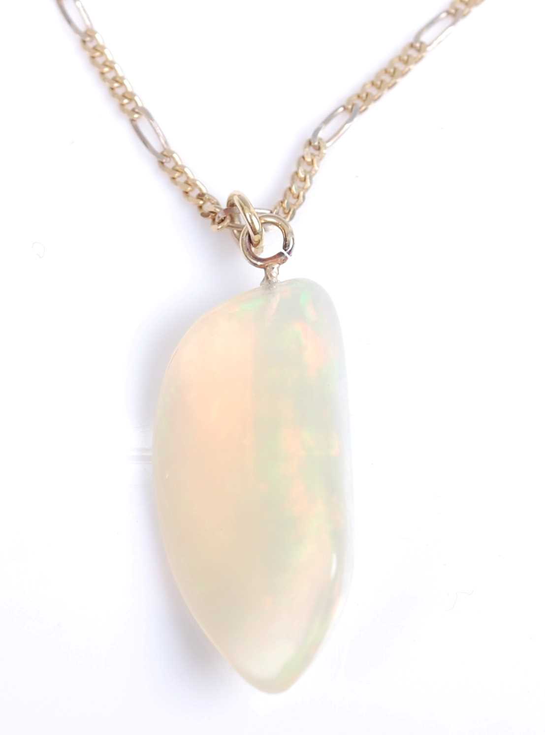 An abstract polished opal pendant, dimensions approx 29 x 15mm, attached to a yellow metal figaro