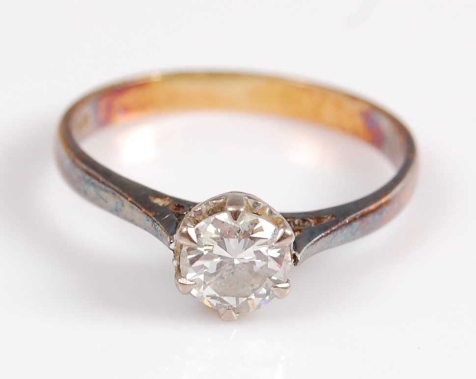 A yellow and white metal single stone diamond ring, featuring a round brilliant cut diamond in a