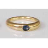 A yellow metal sapphire ring, the oval cut sapphire weighing approx 0.3 carats, sunken to a tapering