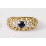 An 18ct gold, sapphire and diamond set dress ring, arranged as a centre round cut sapphire