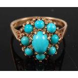 A 9ct yellow gold turquoise set cluster ring, featuring a centre oval and eight round cabochon cut