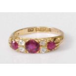 An Edwardian 18ct gold, ruby and diamond ring, arranged as three round cut rubies in a carved