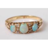 A yellow metal carved head opal and diamond half hoop eternity ring, the three graduated oval opal