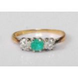 An 18ct gold and platinum, emerald and diamond three-stone ring, the centre four-claw set emerald