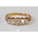 An 18ct gold diamond five stone ring, the graduated claw set old cut diamonds in a line setting,