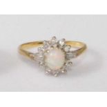 An 18ct gold, opal and diamond dress ring, the centre cabochon opal flanked to either side by twin