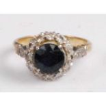 An 18ct gold and platinum, sapphire and diamond cluster ring, arranged as a centre round cut four