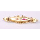 A late Victorian 15ct gold, ruby and diamond set elliptical brooch, having finely worked scroll ends