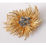 A yellow metal sapphire abstract spray brooch, comprising a centre section of eight round