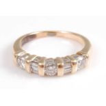 A yellow metal diamond seven stone half hoop eternity ring, comprising three round brilliant cut