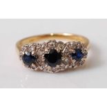 An 18ct yellow and white gold, sapphire and diamond triple cluster ring, featuring three graduated