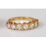 A contemporary 18ct gold diamond seven stone half eternity ring, the brilliants each weighing approx