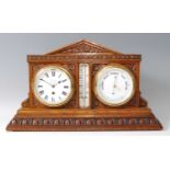 A Victorian carved oak desk weather station, inset with clock and barometer, with central
