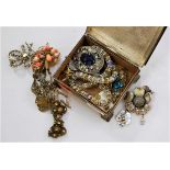 A small metal box and contents of assorted costume jewellery, largely being brooches and neck chains