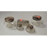 Assorted silver topped glass dressing table tidies (5)Condition report: All lids dented, and the