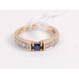 A contemporary 9ct gold sapphire and diamond ring, arranged as a centre oval cut four claw set