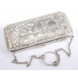 A late Victorian lady's silver evening purse, embossed to one side with an extensive landscape,