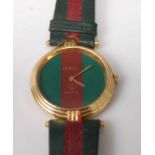 A Gucci gent's quartz wristwatch, in gilt metal case and on two-tone leather bracelet, case dia.