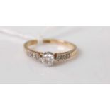 A yellow and white metal diamond single stone ring, featuring a round brilliant cut diamond in