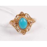 A yellow metal turquoise set dress ring, the cabochon turquoise in a pierced scroll work surround,