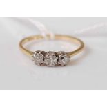 An 18ct gold and platinum diamond three-stone ring, the claw set round cut diamonds weighing