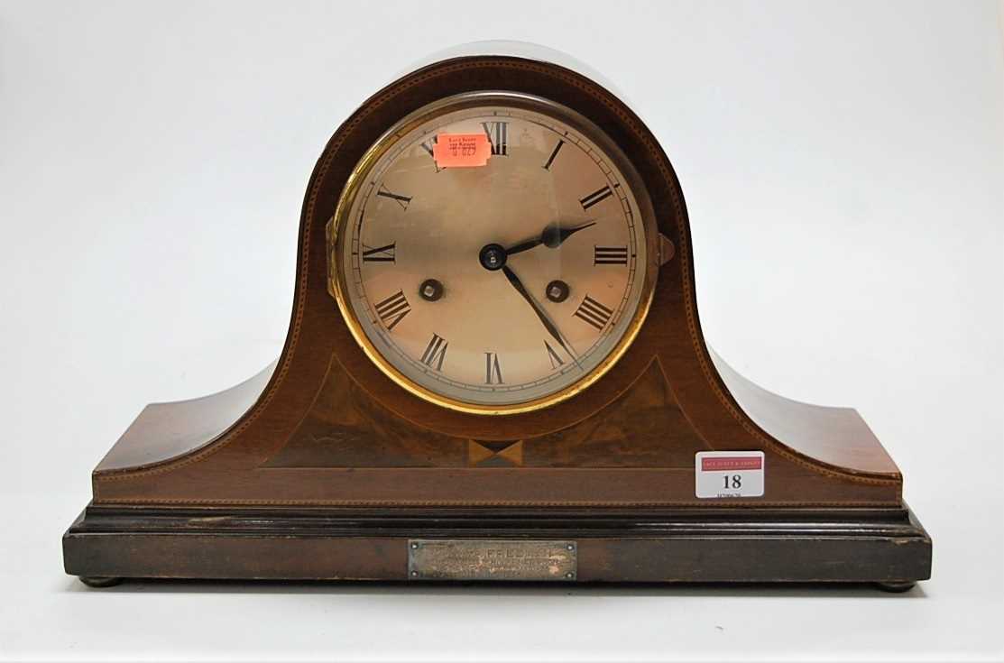 A George V mahogany and inlaid dome topped mantel clock, having striking movement