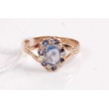 A 9ct gold pale sapphire(?), blue sapphire, and diamond set dress ring, the pale centre sapphire