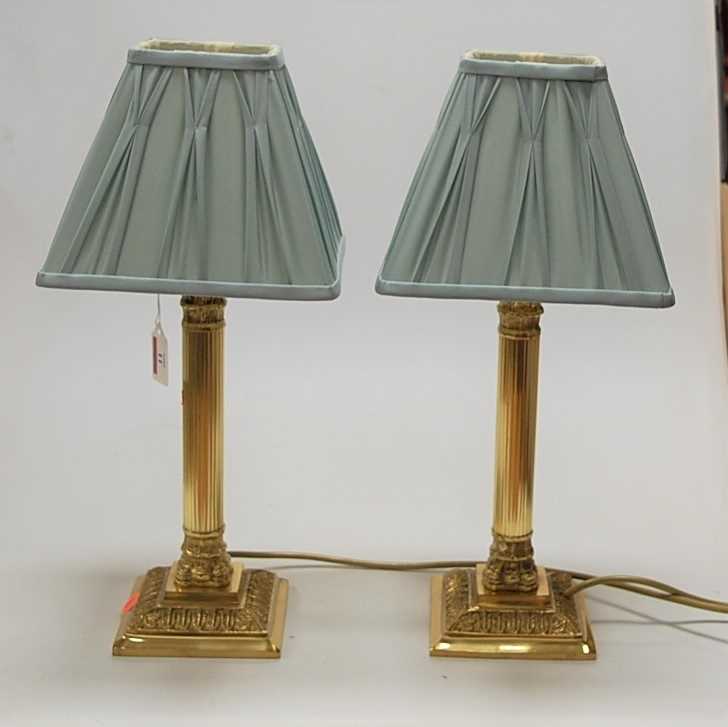 A pair of reproduction lacquered brass bedside lamps, each having pleated silk shades, gross h.42cm