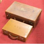 An early 20th century brown stitched leather and brass mounted suitcase; together with one other