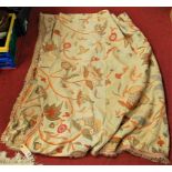 A mid-20th century crewel work tablecloth, floral embroidered in shades of red and green, within