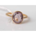 A 9ct yellow gold oval amethyst dress ring, the amethyst in a bezel setting and estimated as